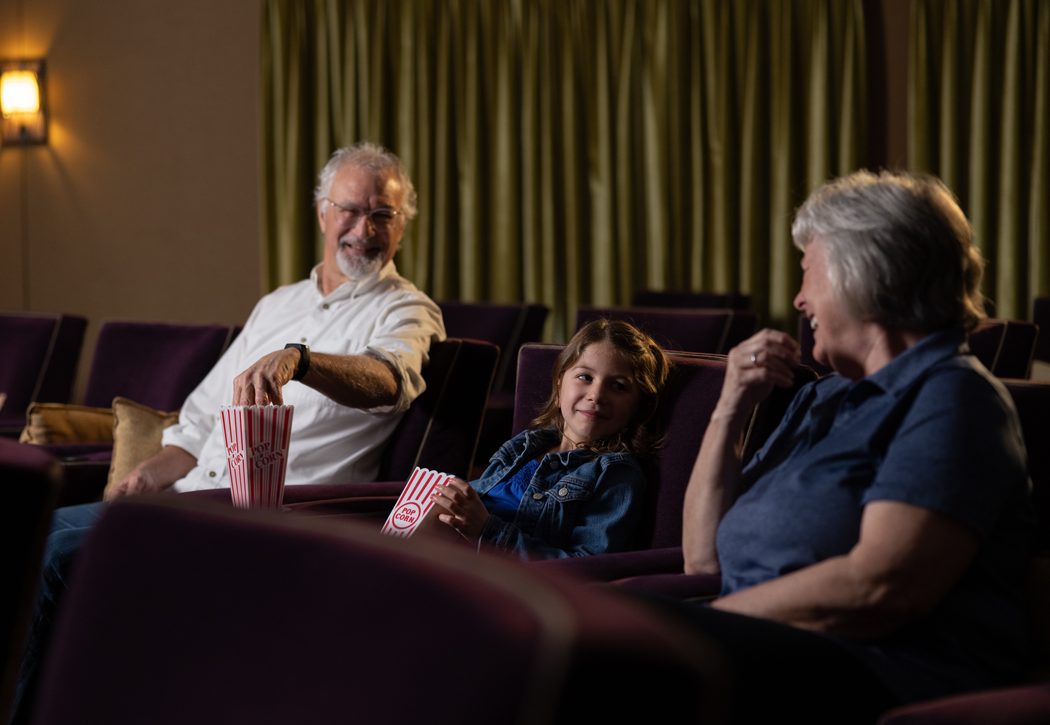 Older couple at the movie theater at garden Spot Village with their granddaughter