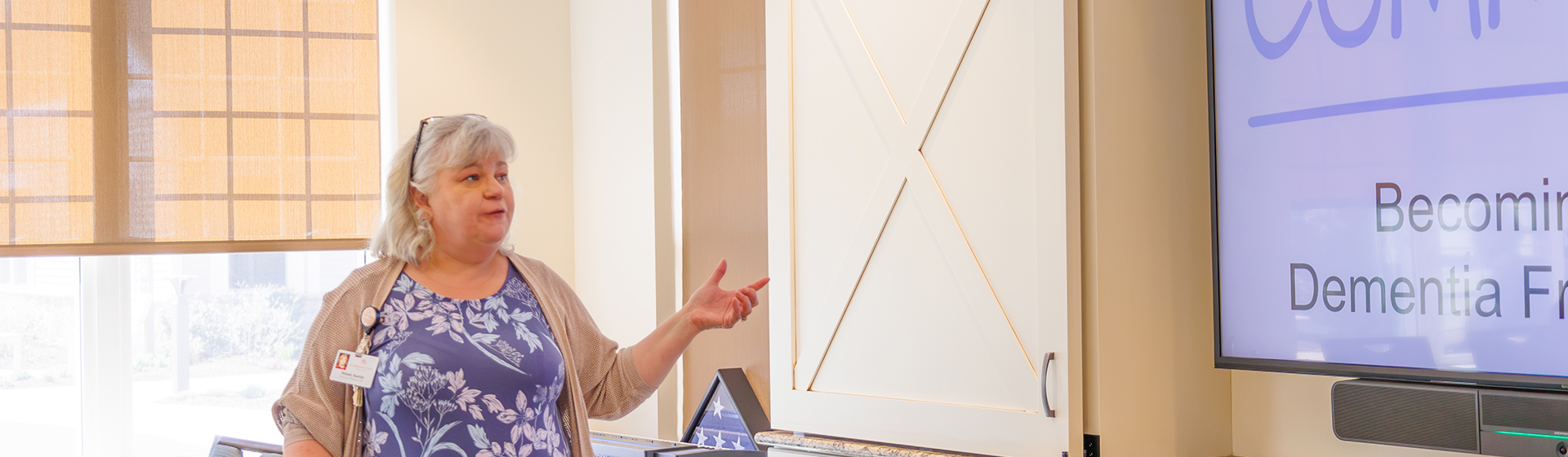 a woman stands in front of a screen that says becoming dementia free