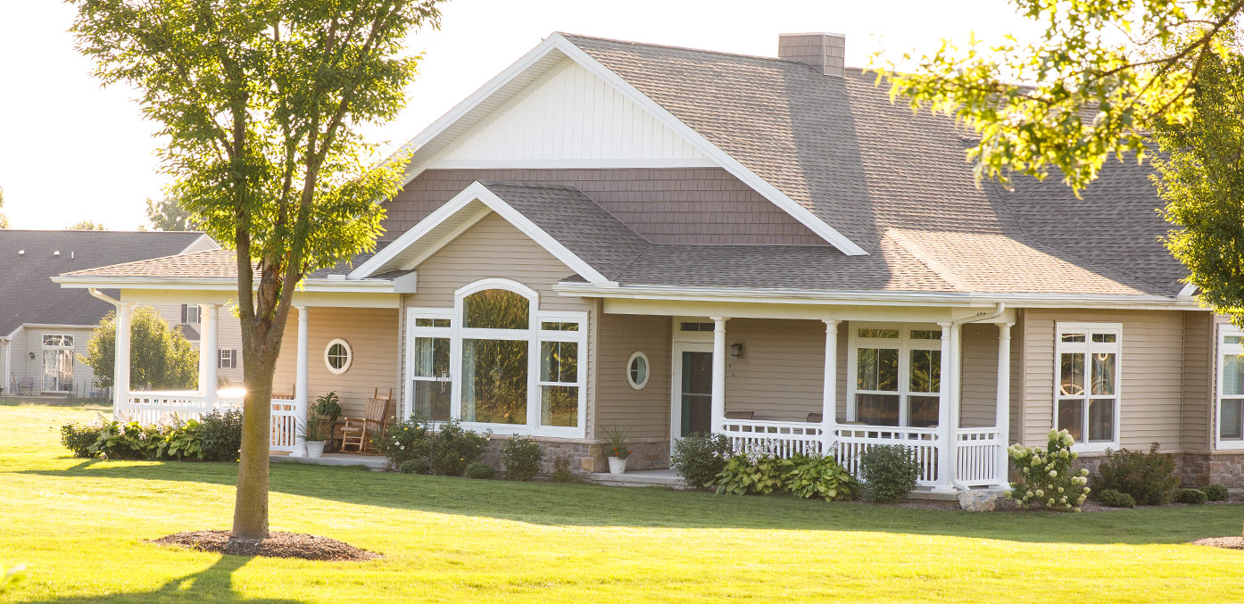 a house with a porch and a tree in front of it
