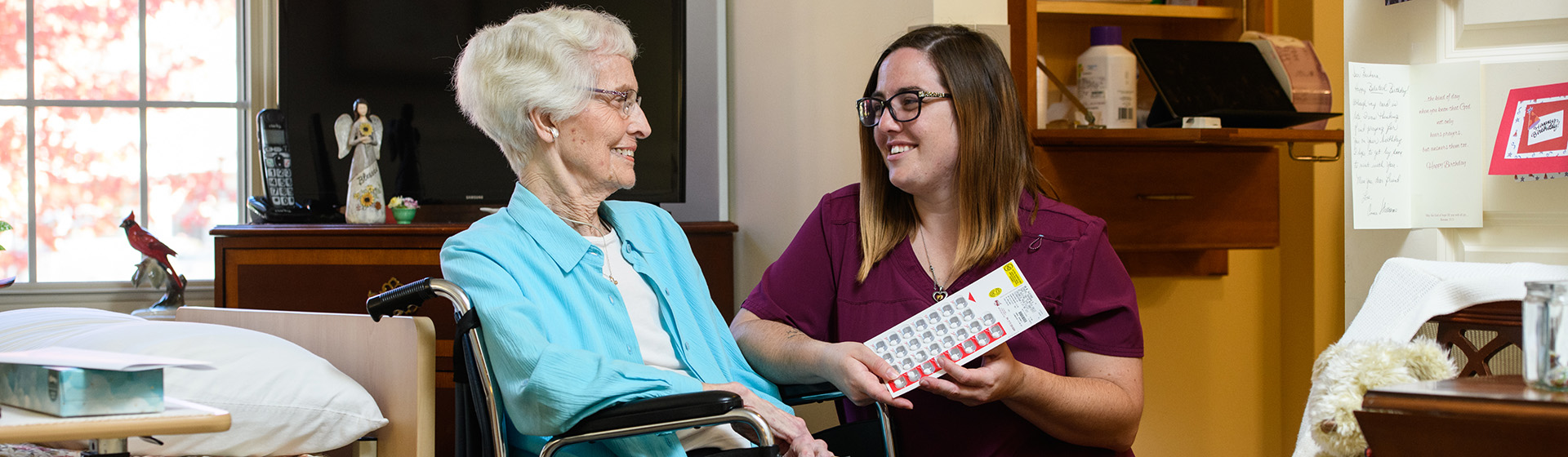 an elderly woman in a wheelchair is being helped by a nurse