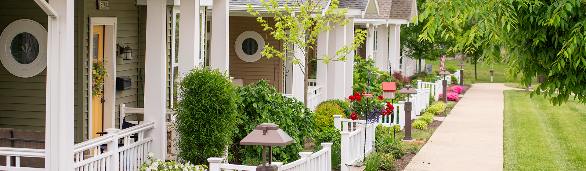 a row of houses with a white fence and a yellow door