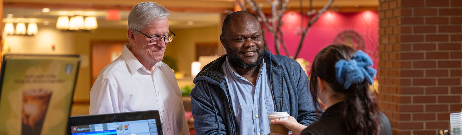 a man is getting a cup of coffee from a woman
